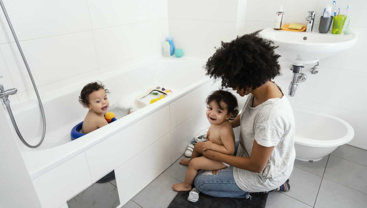A mother with two young children enjoying bathtime