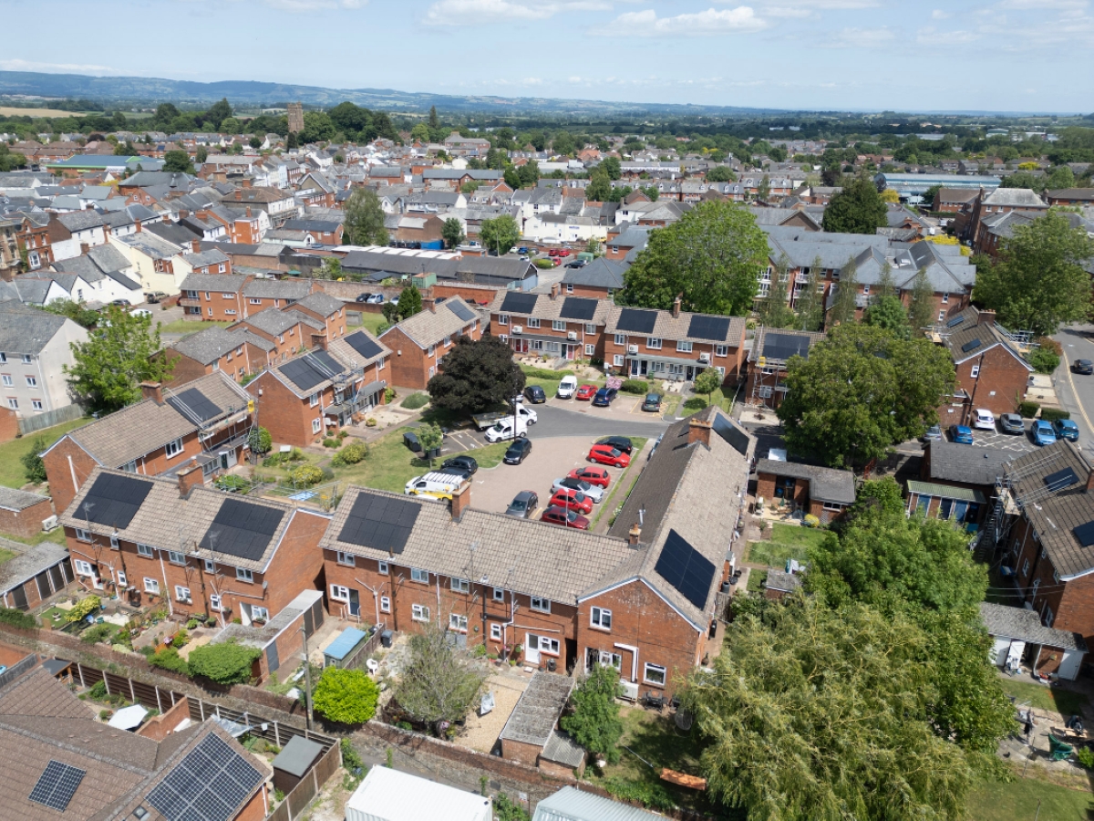 Aerial view of block of houses with solar panels on roofs.