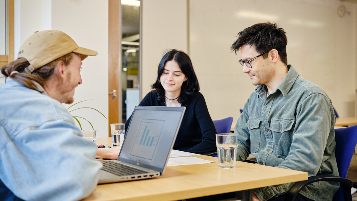 energy advisor with their laptop speaking to two people across a table